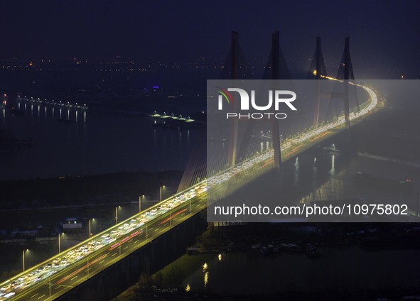 A large number of vehicles are traveling slowly on the section of the Huaian Bridge on the Changzhou-Shenzhen Expressway in Huai'an, China,...