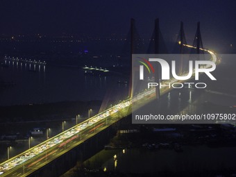 A large number of vehicles are traveling slowly on the section of the Huaian Bridge on the Changzhou-Shenzhen Expressway in Huai'an, China,...