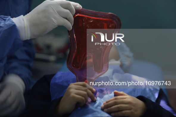 A child is receiving pediatric dental care as part of Dentist Day in Mexico at the Carlos A. Carrilo Elementary School in the Portales neigh...