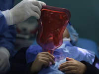 A child is receiving pediatric dental care as part of Dentist Day in Mexico at the Carlos A. Carrilo Elementary School in the Portales neigh...