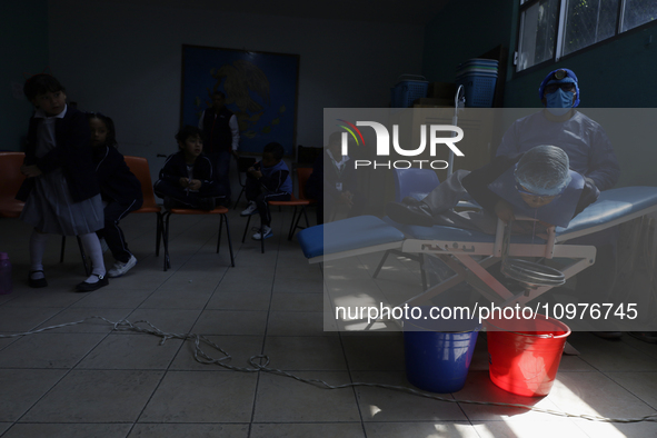 A child is receiving pediatric dental care as part of Dentist Day in Mexico at the Carlos A. Carrilo Elementary School in the Portales neigh...