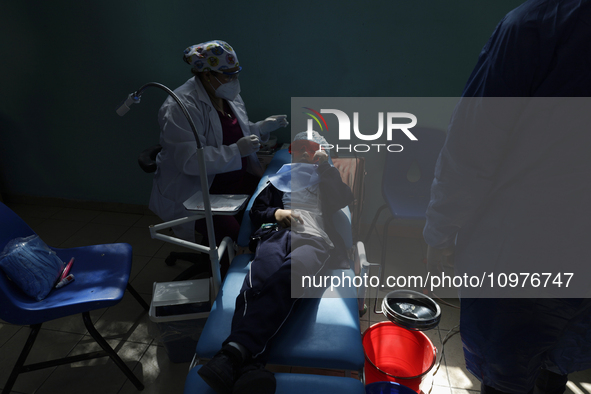 A child is receiving pediatric dental care as part of Dentist Day in Mexico at the Carlos A. Carrilo Elementary School in the Portales neigh...