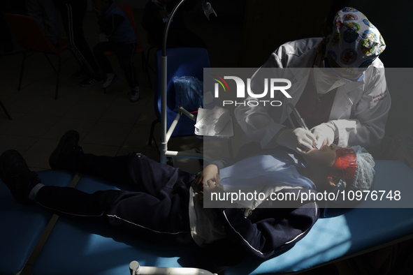 A child is receiving pediatric dental care as part of Dentist Day in Mexico at the Carlos A. Carrilo Elementary School in the Portales neigh...