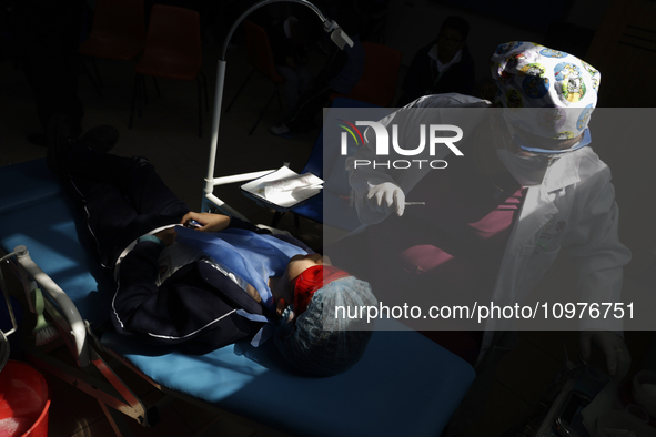 A child is receiving pediatric dental care as part of Dentist Day in Mexico at the Carlos A. Carrilo Elementary School in the Portales neigh...