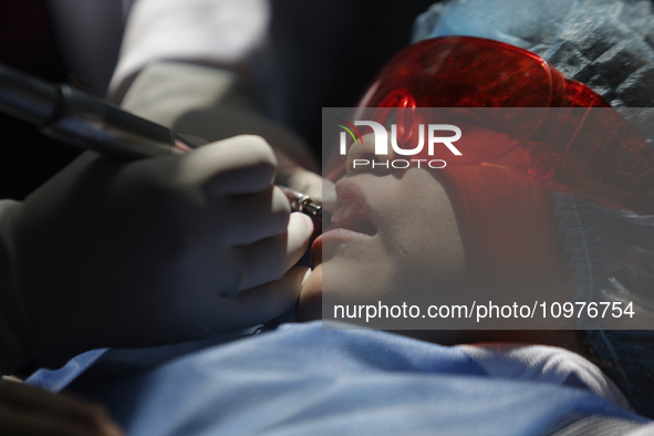 A child is receiving pediatric dental care as part of Dentist Day in Mexico at the Carlos A. Carrilo Elementary School in the Portales neigh...