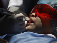 A child is receiving pediatric dental care as part of Dentist Day in Mexico at the Carlos A. Carrilo Elementary School in the Portales neigh...