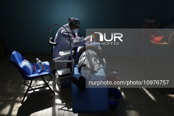 A child is receiving pediatric dental care as part of Dentist Day in Mexico at the Carlos A. Carrilo Elementary School in the Portales neigh...