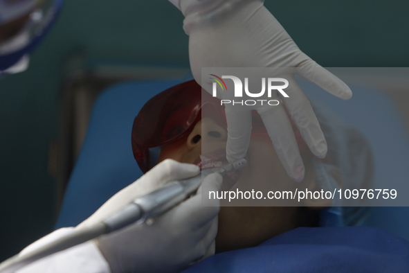 A child is receiving pediatric dental care as part of Dentist Day in Mexico at the Carlos A. Carrilo Elementary School in the Portales neigh...