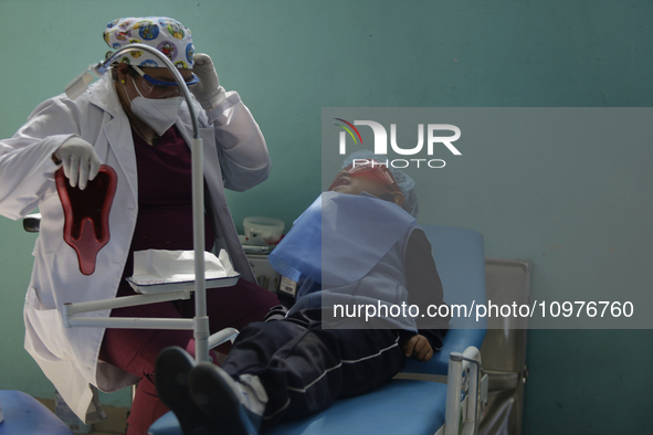 A child is receiving pediatric dental care as part of Dentist Day in Mexico at the Carlos A. Carrilo Elementary School in the Portales neigh...