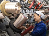 A textile worker is working at a production line of a chemical fiber company in Taizhou, China, on February 10, 2024. (