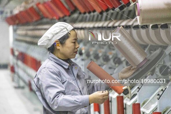 A textile worker is working at a production line of a chemical fiber company in Taizhou, China, on February 10, 2024. 