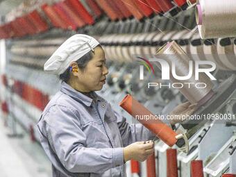 A textile worker is working at a production line of a chemical fiber company in Taizhou, China, on February 10, 2024. (