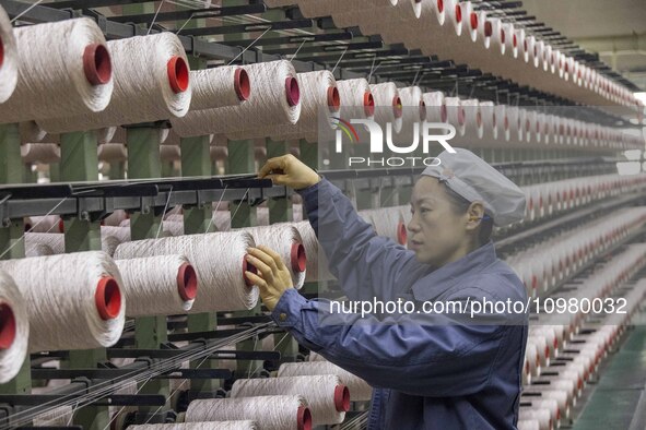 A textile worker is working at a production line of a chemical fiber company in Taizhou, China, on February 10, 2024. 