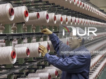 A textile worker is working at a production line of a chemical fiber company in Taizhou, China, on February 10, 2024. (