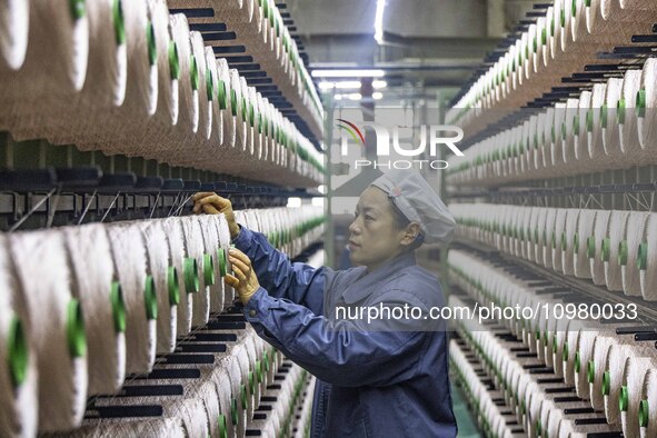 A textile worker is working at a production line of a chemical fiber company in Taizhou, China, on February 10, 2024. 