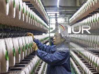 A textile worker is working at a production line of a chemical fiber company in Taizhou, China, on February 10, 2024. (