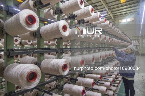 A textile worker is working at a production line of a chemical fiber company in Taizhou, China, on February 10, 2024. 