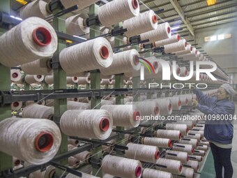 A textile worker is working at a production line of a chemical fiber company in Taizhou, China, on February 10, 2024. (