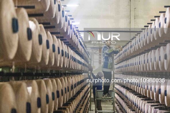 A textile worker is working at a production line of a chemical fiber company in Taizhou, China, on February 10, 2024. 