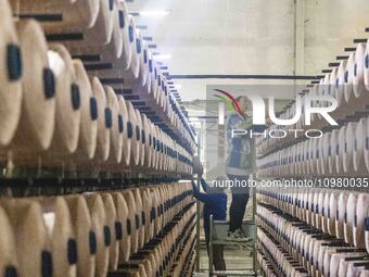 A textile worker is working at a production line of a chemical fiber company in Taizhou, China, on February 10, 2024. (