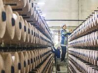 A textile worker is working at a production line of a chemical fiber company in Taizhou, China, on February 10, 2024. (