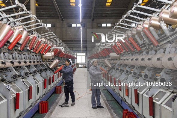 A textile worker is working at a production line of a chemical fiber company in Taizhou, China, on February 10, 2024. 