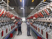 A textile worker is working at a production line of a chemical fiber company in Taizhou, China, on February 10, 2024. (