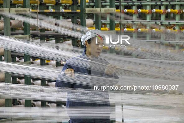 A textile worker is working at a production line of a chemical fiber company in Taizhou, China, on February 10, 2024. 