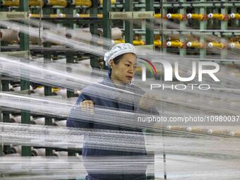 A textile worker is working at a production line of a chemical fiber company in Taizhou, China, on February 10, 2024. (