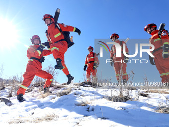 Firefighters are crossing a ditch to patrol forest grassland protection in Zhangye, China, on February 10, 2024. (