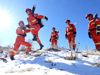 Firefighters are crossing a ditch to patrol forest grassland protection in Zhangye, China, on February 10, 2024. (