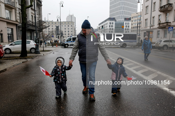 A man with small girls holding Polish national flags attend a protest, led by far right media - Gazeta Polska and TV Republica and Law and J...