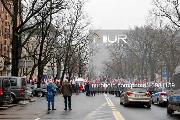 A amall crowd of people, holding Polish national flags and anti-government banners, led by far right media - Gazeta Polska and TV Republica...