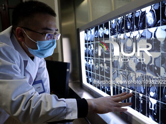 A doctor is checking a patient's CT scan at the imaging department of Boxing County Traditional Chinese Medicine Hospital in Binzhou, China,...