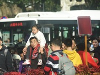 A child is riding on his parents' shoulders to visit the broken West Lake Bridge in Hangzhou, Zhejiang Province, China, on February 11, 2024...