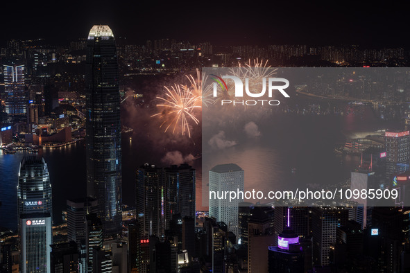 Fireworks are exploding over Victoria Harbour next to skyscrapers in Central in Hong Kong, on February 11, 2024. This is the first Lunar New...