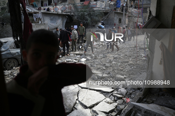 Palestinians are inspecting the damage caused by Israeli bombardment in Deir al-Balah, central Gaza Strip, on February 12, 2024, as battles...