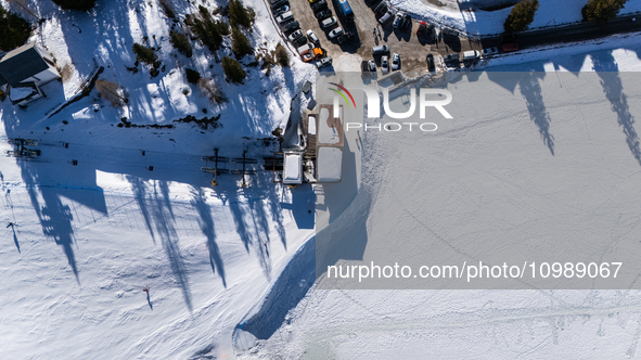 A drone view of the people skiing in Misurina-Col de Varda and the frozen Lake Misurina, blanketed in snow, in Misurina, Italy, on February...