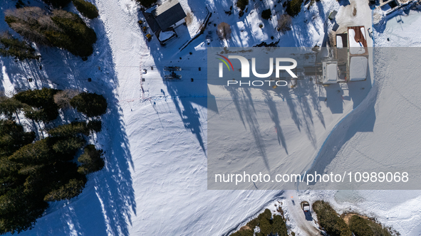 A drone view of the people skiing in Misurina-Col de Varda and the frozen Lake Misurina, blanketed in snow, in Misurina, Italy, on February...