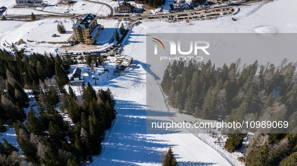 A drone view of the people skiing in Misurina-Col de Varda and the frozen Lake Misurina, blanketed in snow, in Misurina, Italy, on February...