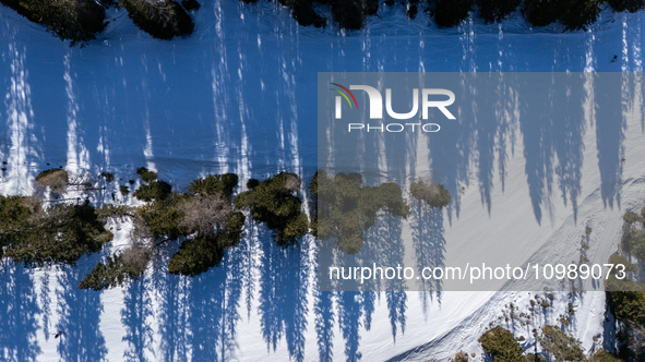 A drone view of the people skiing in Misurina-Col de Varda and the frozen Lake Misurina, blanketed in snow, in Misurina, Italy, on February...