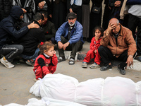 Palestinians are mourning their relatives, who were killed in an overnight Israeli strike on Deir al-Balah, during a mass funeral at the Al-...