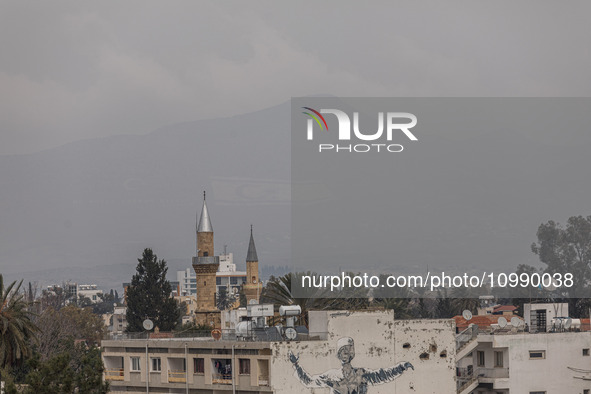 The flag of the so-called ''Turkish Republic of Northern Cyprus'' is barely visible on Pentadaktylos mountain behind a mosque minaret in the...