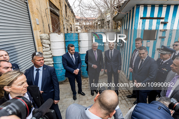 Constantinos Yiorkadjis, Frank-Walter Steinmeier, and Nikos Christodoulides are posing in front of a barricade in Nicosia, Cyprus, on Februa...