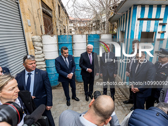 Constantinos Yiorkadjis, Frank-Walter Steinmeier, and Nikos Christodoulides are posing in front of a barricade in Nicosia, Cyprus, on Februa...