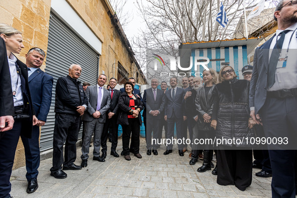 Constantinos Yiorkadjis, Frank-Walter Steinmeier, and Nikos Christodoulides are posing in front of a barricade in Nicosia, Cyprus, on Februa...