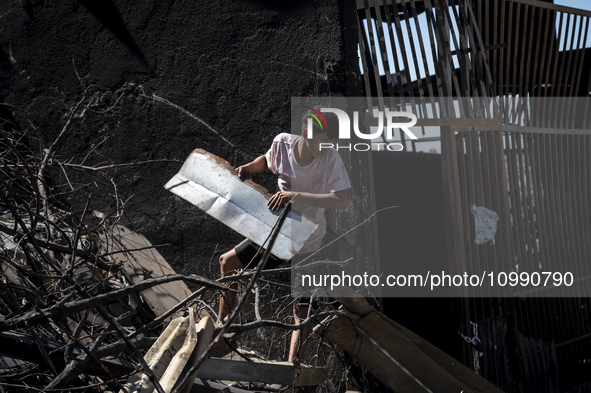 A person is removing debris in Villa Independencia, a place devastated by the mega fire. 