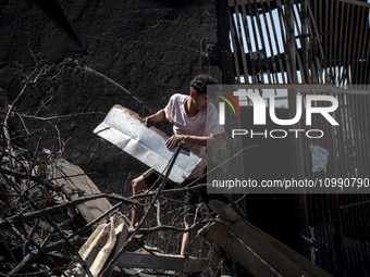 A person is removing debris in Villa Independencia, a place devastated by the mega fire. (