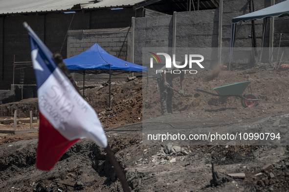 A person is removing debris in Villa Independencia, an area devastated by the mega fire. 