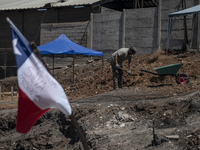 A person is removing debris in Villa Independencia, an area devastated by the mega fire. (